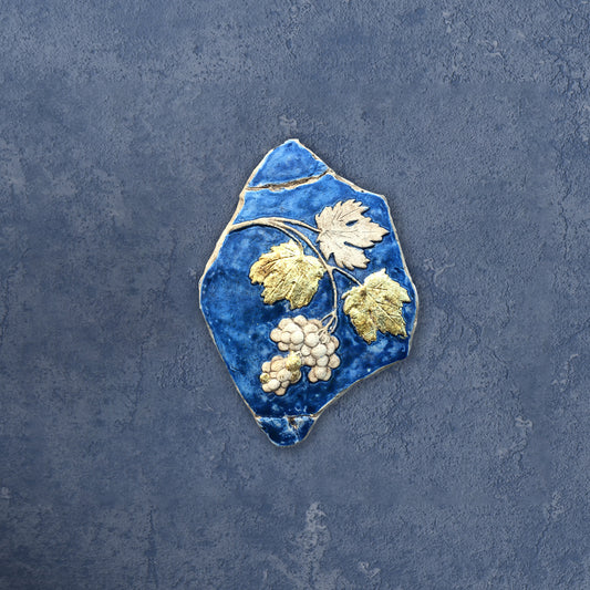 Tralcio d'uva: scultura in ceramica con dorature