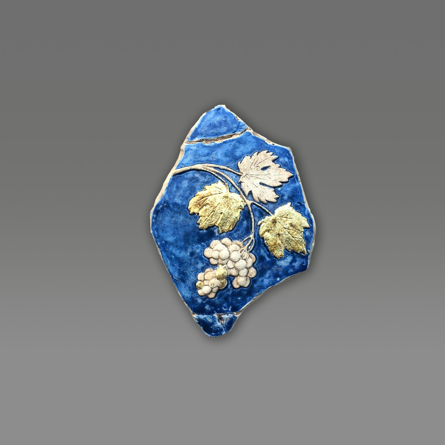 Tralcio d'uva: scultura in ceramica con dorature