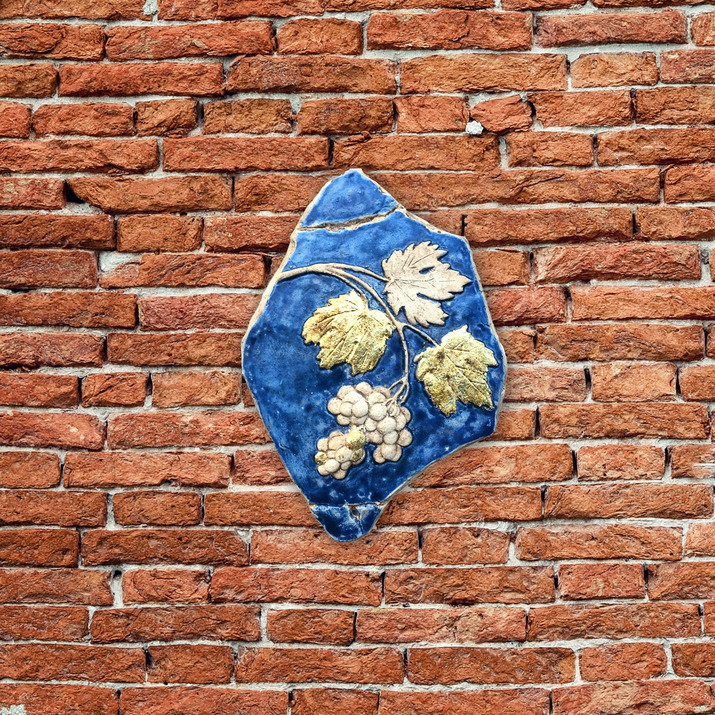 Tralcio d'uva: scultura in ceramica con dorature