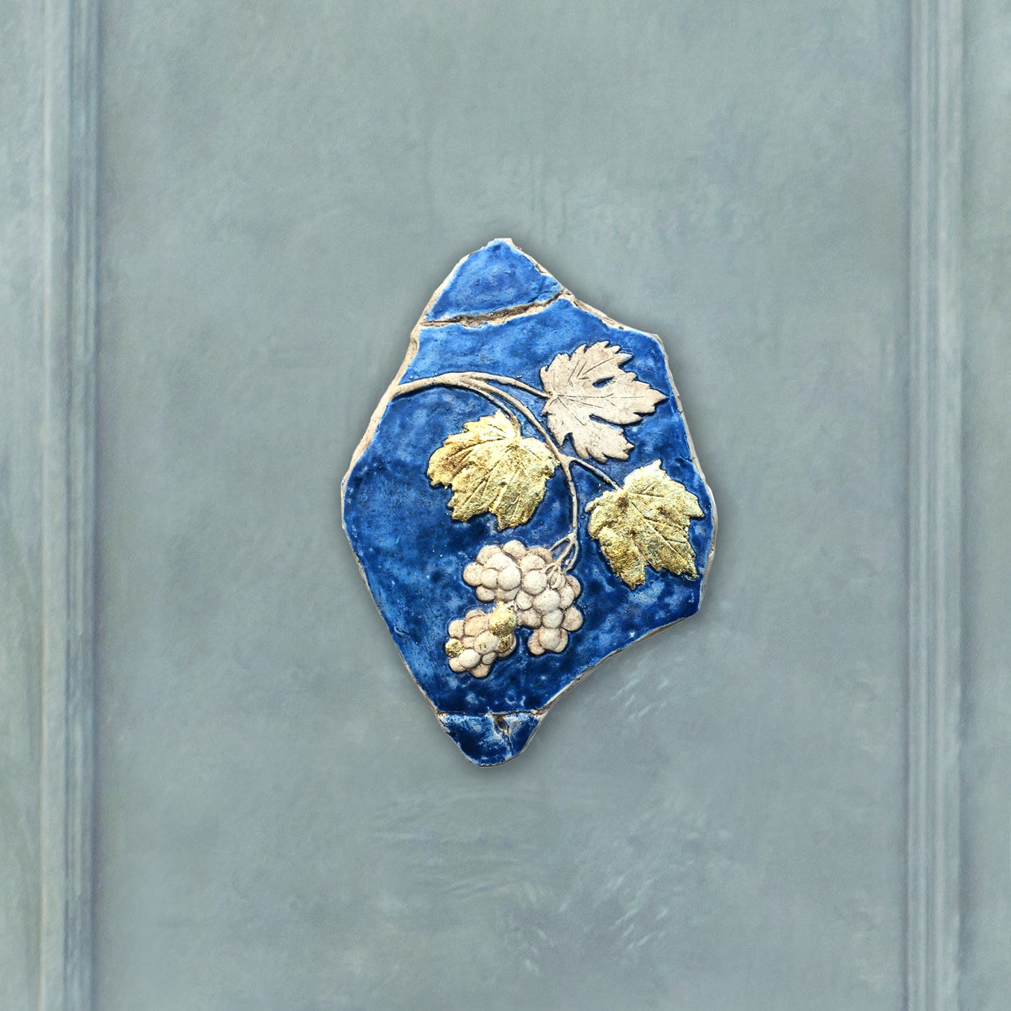 Tralcio d'uva: scultura in ceramica con dorature