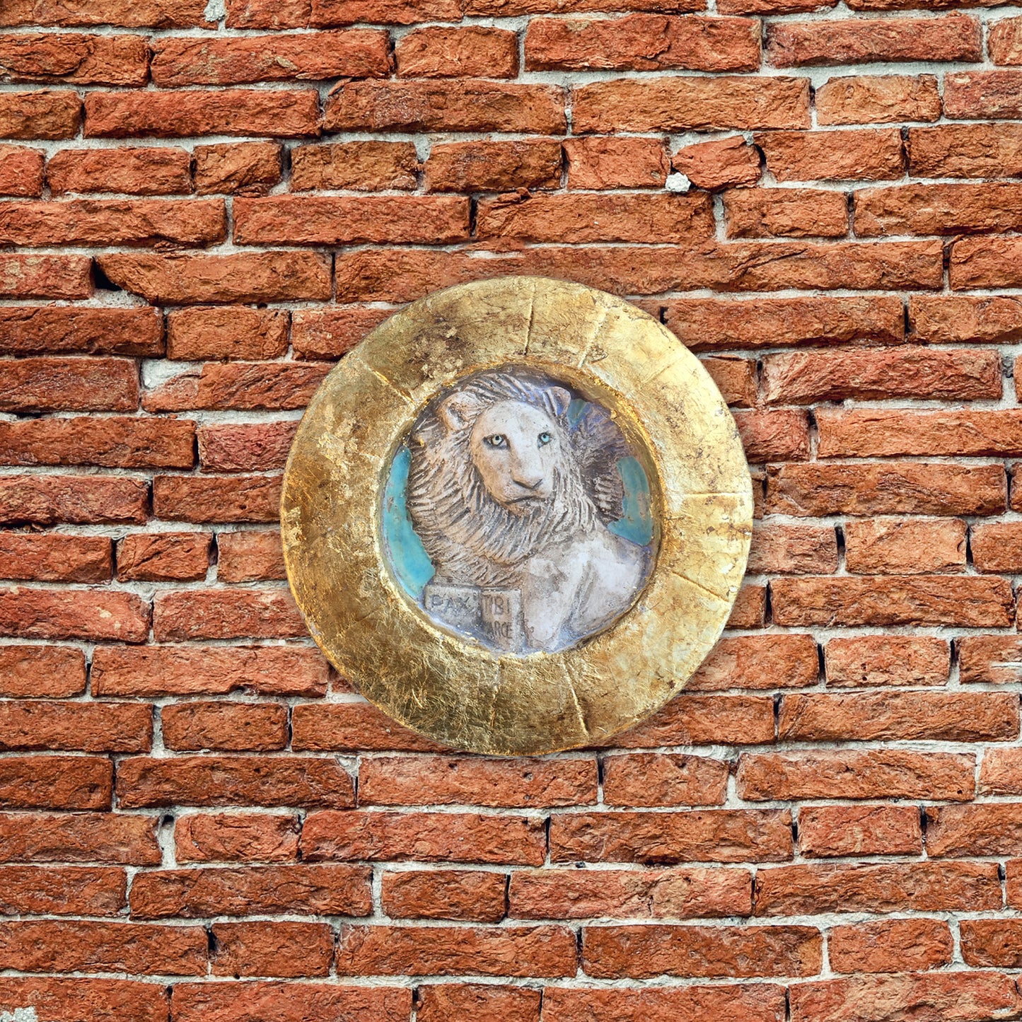 Piccolo Leone di San Marco entro tondo, con cornice dorata.