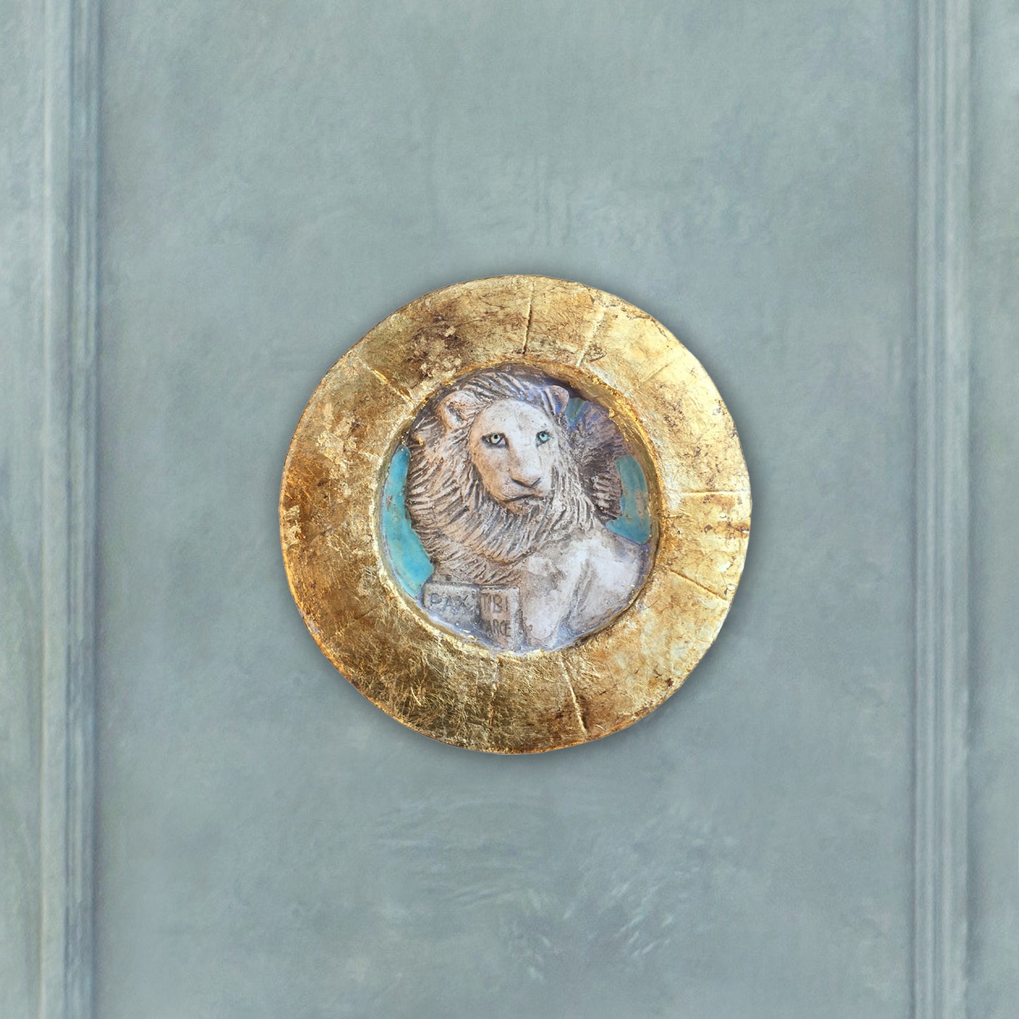 Piccolo Leone di San Marco entro tondo, con cornice dorata.